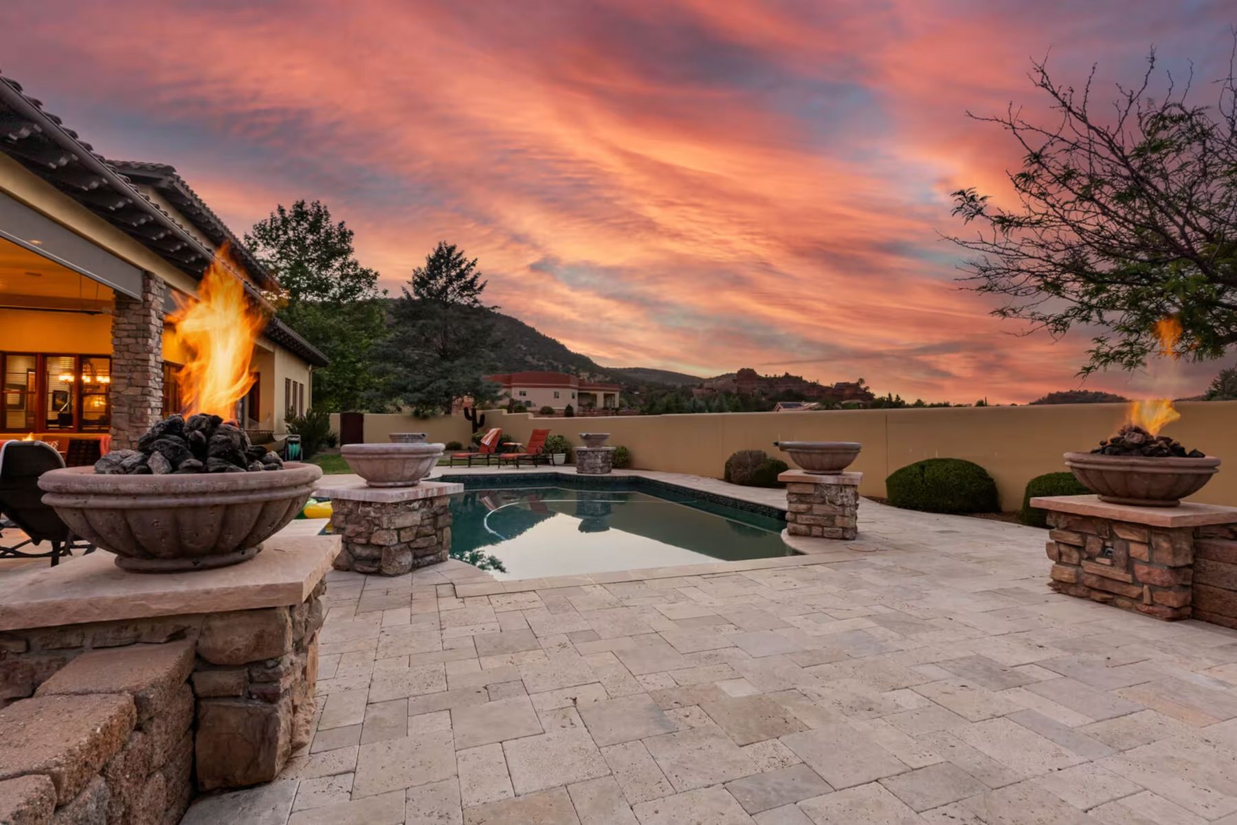 The retreat home's pool and fire bowls under a blazing Sedona sunset